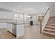 Open-concept living space with bright white walls, hardwood floors, and a staircase leading to the upper level at 52 Brunello Ct, Clayton, NC 27527