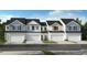 Charming townhome exterior with a crisp white and gray palette and individual garage doors at 520 Sunset Lake Dr, Durham, NC 27704
