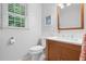 This is a bathroom with a neutral color scheme, featuring a toilet, wood vanity and matching mirror, as well as tiled backsplash at 526 Colony Woods Dr, Chapel Hill, NC 27517