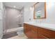Bright bathroom featuring a glass shower, gray tiled walls, white countertop and brown vanity at 526 Colony Woods Dr, Chapel Hill, NC 27517