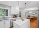 Open-concept kitchen with white cabinets, a central island, and adjacent dining area, great for entertaining at 526 Colony Woods Dr, Chapel Hill, NC 27517
