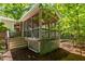 Exterior view of a screened porch featuring wood framing, a lattice base, steps and an adjacent landscaped yard at 526 Colony Woods Dr, Chapel Hill, NC 27517