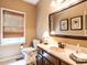Bathroom with vanity, decorative mirror, and window with bamboo blinds at 5317 Deep Valley, Raleigh, NC 27606