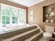 Elegant bathroom showcasing a soaking tub with steps and a large window offering natural light at 5317 Deep Valley, Raleigh, NC 27606