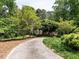 Long driveway leading to a beautiful home surrounded by lush greenery and mature trees at 5317 Deep Valley, Raleigh, NC 27606