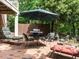 Brick patio with outdoor seating, umbrella, and grill, surrounded by greenery at 5317 Deep Valley, Raleigh, NC 27606