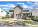 View of the back of a two-story home, deck, stone patio, and landscaped backyard at 533 Opposition Way, Wake Forest, NC 27587