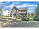 Two-story home with spacious backyard, deck, manicured lawn, and a stone patio at 533 Opposition Way, Wake Forest, NC 27587