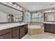 Relax in this Primary bathroom featuring dual vanities, framed mirrors, tiled flooring and a large soaking tub at 533 Opposition Way, Wake Forest, NC 27587