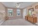 Comfortable bedroom featuring carpeted floors, neutral walls, two windows, and a ceiling fan at 533 Opposition Way, Wake Forest, NC 27587