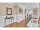 Upstairs hallway with hardwood floors, decorative molding, and staircase with iron balusters at 533 Opposition Way, Wake Forest, NC 27587