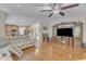 Open concept living room with hardwood floors, ceiling fan, and large entertainment center at 533 Opposition Way, Wake Forest, NC 27587