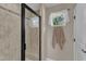 This bathroom features a glass shower, window with sheer curtains, neutral walls and tile flooring at 533 Opposition Way, Wake Forest, NC 27587