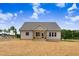 View of the home's backyard featuring a screened-in porch, and a freshly seeded lawn at 56 Birchtop Cir, Zebulon, NC 27597
