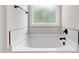 Relaxing soaking tub with neutral tile backsplash and a frosted window at 56 Birchtop Cir, Zebulon, NC 27597