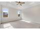 Spacious bedroom with neutral carpet, ceiling fan, and bright natural light from the windows at 56 Birchtop Cir, Zebulon, NC 27597