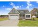 Charming new construction home featuring a two-car garage and a well-manicured front yard at 56 Birchtop Cir, Zebulon, NC 27597