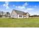A bright and welcoming home with a large lawn and beautiful architectural details under a partly cloudy sky at 56 Birchtop Cir, Zebulon, NC 27597