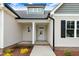 Close-up of front entrance featuring a white front door and tasteful landscaping at 56 Birchtop Cir, Zebulon, NC 27597