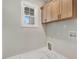 This is a laundry room with wooden upper cabinets and marble-look tile floors at 56 Birchtop Cir, Zebulon, NC 27597