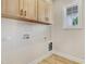 Laundry room with wooden cabinets, a window, and hookups for a washer and dryer at 56 Birchtop Cir, Zebulon, NC 27597