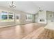 Open-concept living room with hardwood floors, vaulted ceilings, fireplace, and large windows at 56 Birchtop Cir, Zebulon, NC 27597