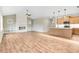 Living room flowing into a modern kitchen, featuring hardwood floors and vaulted ceilings at 56 Birchtop Cir, Zebulon, NC 27597