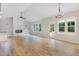 Spacious living room with a shiplap fireplace, lots of windows, and wood-look flooring at 56 Birchtop Cir, Zebulon, NC 27597