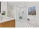 Bright bathroom features a walk-in glass shower and free-standing tub with patterned floors at 596 Oaks Lane Rd, Timberlake, NC 27583