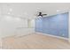 Spacious bonus room features a paneled blue wall, wood-look floors, and a ceiling fan at 596 Oaks Lane Rd, Timberlake, NC 27583