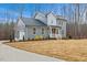 Charming two-story home featuring gray siding, black roof, and a cozy front porch with white railings and driveway at 596 Oaks Lane Rd, Timberlake, NC 27583