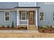 Close-up of the home's charming front porch with wooden door, white railings, and landscaped garden beds at 596 Oaks Lane Rd, Timberlake, NC 27583