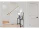 Bright hallway with a wood staircase and table under a lamp on light wood floors at 596 Oaks Lane Rd, Timberlake, NC 27583