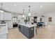 Spacious open kitchen with gray island, white cabinets, stainless appliances, and pendant lighting at 596 Oaks Lane Rd, Timberlake, NC 27583