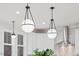 Pendant lights above the kitchen island illuminate this modern space with white cabinets and a stainless steel hood at 596 Oaks Lane Rd, Timberlake, NC 27583