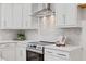 Modern kitchen with stainless steel oven and range hood, subway tile backsplash, and white cabinets at 596 Oaks Lane Rd, Timberlake, NC 27583