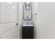 Stylish powder room with black vanity, decorative mirror, and contemporary lighting at 596 Oaks Lane Rd, Timberlake, NC 27583