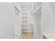 Bright walk-in closet features built-in white shelving and light wood-look flooring at 596 Oaks Lane Rd, Timberlake, NC 27583