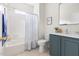 Updated bathroom with blue vanity, shower and tub with patterned curtain at 608 Elin Ct, Hillsborough, NC 27278