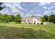 Beautiful white home with manicured lawn and lush green trees at 608 Elin Ct, Hillsborough, NC 27278