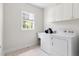 Bright laundry room with white washer and dryer, sink, and storage cabinets at 608 Elin Ct, Hillsborough, NC 27278