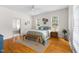 Bright main bedroom with hardwood floors, ceiling fan, and ensuite bathroom view at 608 Elin Ct, Hillsborough, NC 27278
