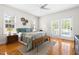 A sunlit main bedroom boasts hardwood floors and charming French doors to an outdoor patio at 608 Elin Ct, Hillsborough, NC 27278