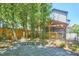 Landscaped backyard featuring a covered patio, stone features, and a wooden fence surrounded by mature trees at 631 Linfield Dr, Durham, NC 27701