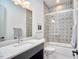 Stylish bathroom with a quartz countertop, decorative tile, and glass enclosed tub/shower at 631 Linfield Dr, Durham, NC 27701