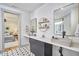 Dual sink bathroom featuring modern fixtures, patterned tile floor, and decorative gold shelving at 631 Linfield Dr, Durham, NC 27701