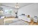 Spacious room with light wood flooring, large windows, and modern lighting fixture at 631 Linfield Dr, Durham, NC 27701