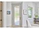 Bright entryway featuring a textured glass door, elegant artwork, and a comfortable chair at 631 Linfield Dr, Durham, NC 27701
