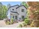 Charming renovated two-story home with white brick, black trim, manicured landscaping, and covered front porch at 631 Linfield Dr, Durham, NC 27701