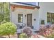 Covered front porch with black framed windows, seating area, and beautifully landscaped front yard at 631 Linfield Dr, Durham, NC 27701